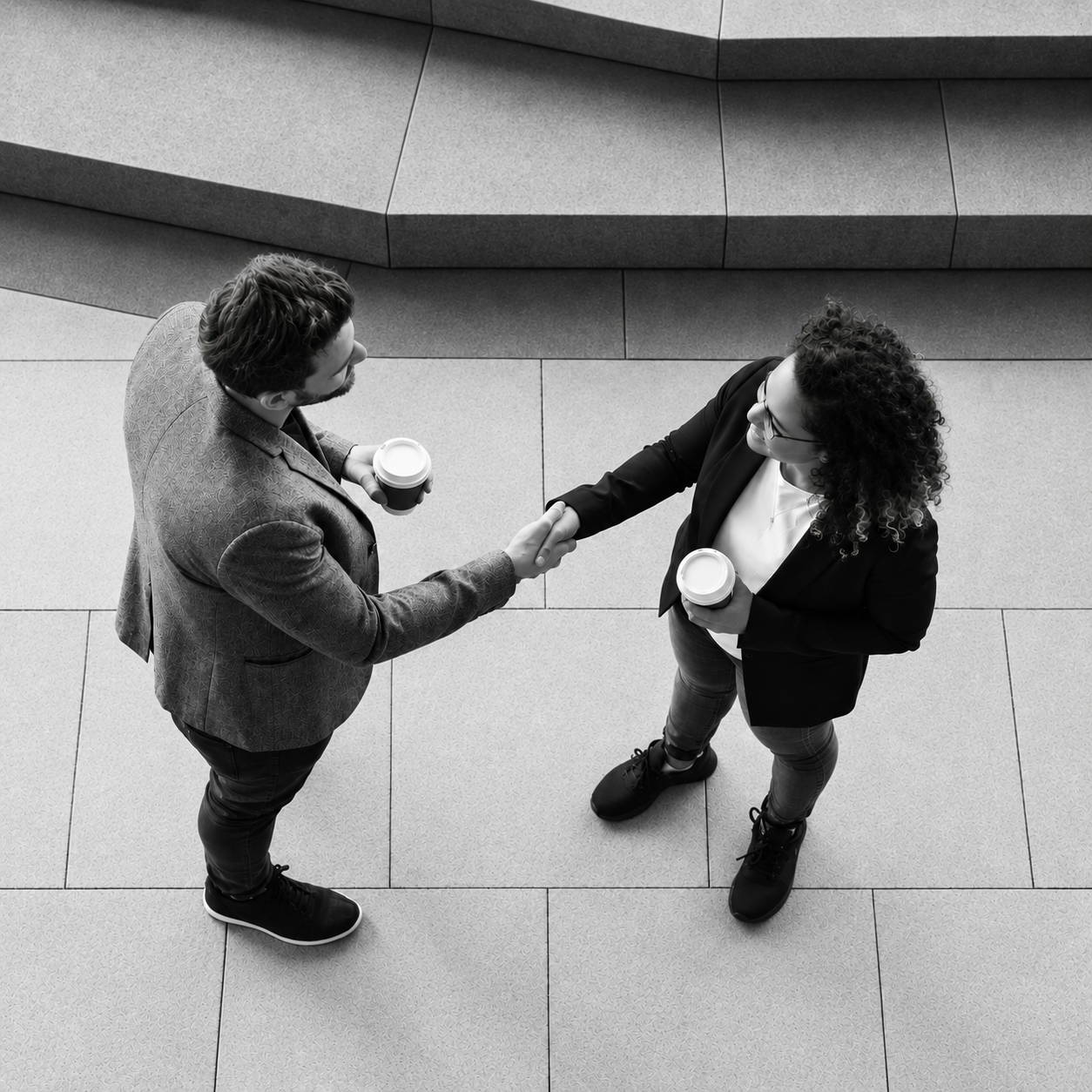 Two professionals shaking hands in a modern plaza